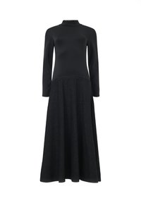Langarm jurk met een aansluitende zwarte top en een vloeiende zwarte rok van zacht, textuurachtig materiaal. Naaddetails voegen visueel belang toe.