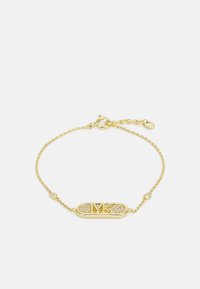 Bracciale in tonalità oro con un ciondolo centrale ovale con il logo "MK" e pietre trasparenti incastonate, collegato da una delicata catena attorcigliata.