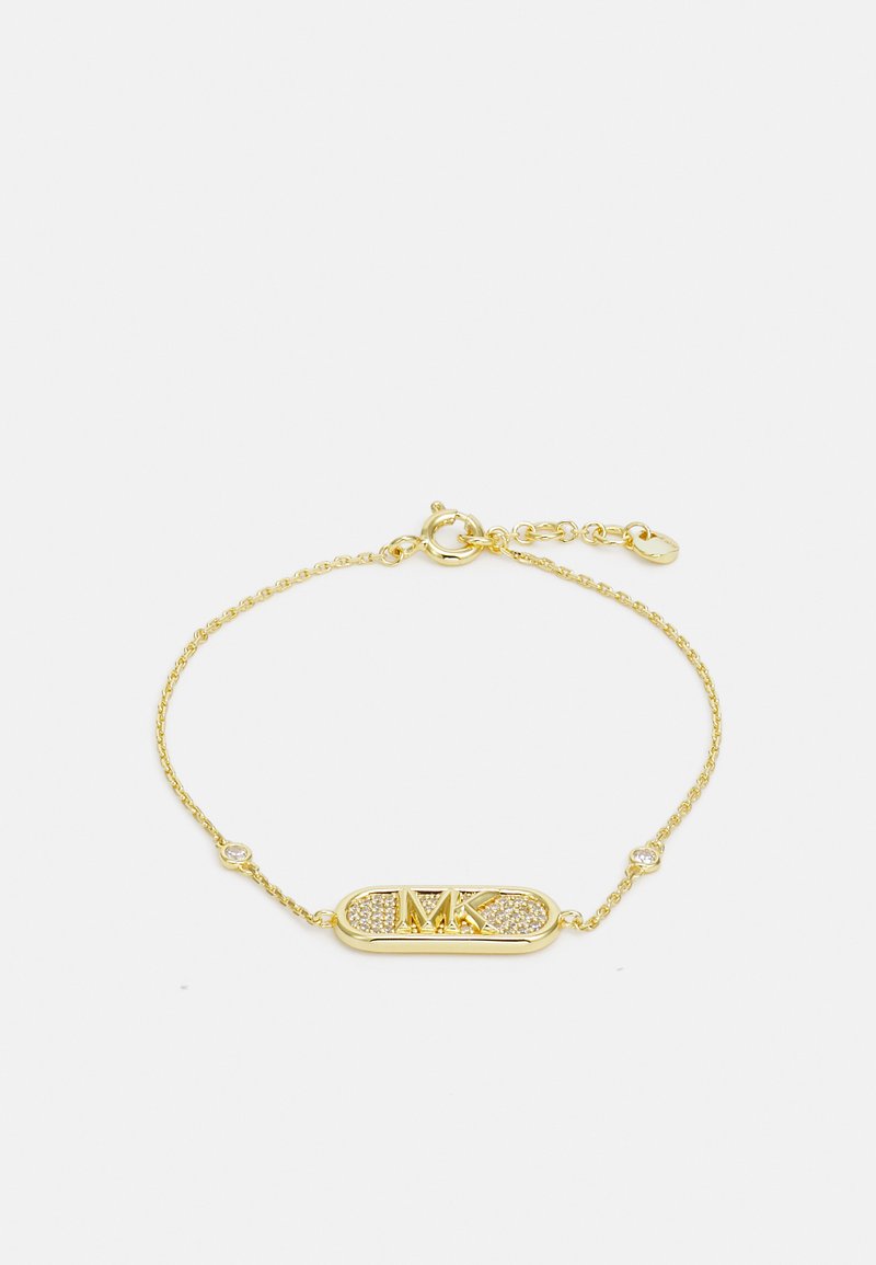 Bracciale in tonalità oro con un ciondolo centrale ovale con il logo "MK" e pietre trasparenti incastonate, collegato da una delicata catena attorcigliata.