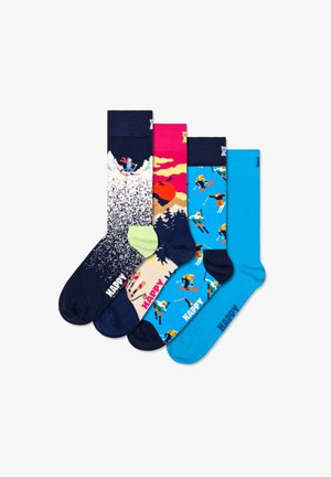 Vier paar kleurrijke sokken: marineblauw met skiloperontwerp, roze en geel zonsondergangthema, blauw met verschillende skiërs, en effen blauw met de tekst "HAPPY".