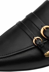 Juodi odiniai bateliai su dvigubomis dirželiais, auksinėmis apskritomis detalėmis ir tekstūruota paviršiaus. Turi smaigaliuoto piršto formą ir lygų siuvimą.