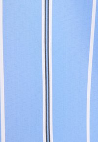Gros plan d’un tissu bleu avec un motif de rayures blanches verticales fines et noires.