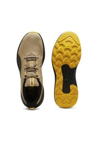 Beige athletic shoes with mesh and synthetic upper, featuring black accents and a yellow rubber sole with a textured grip pattern.