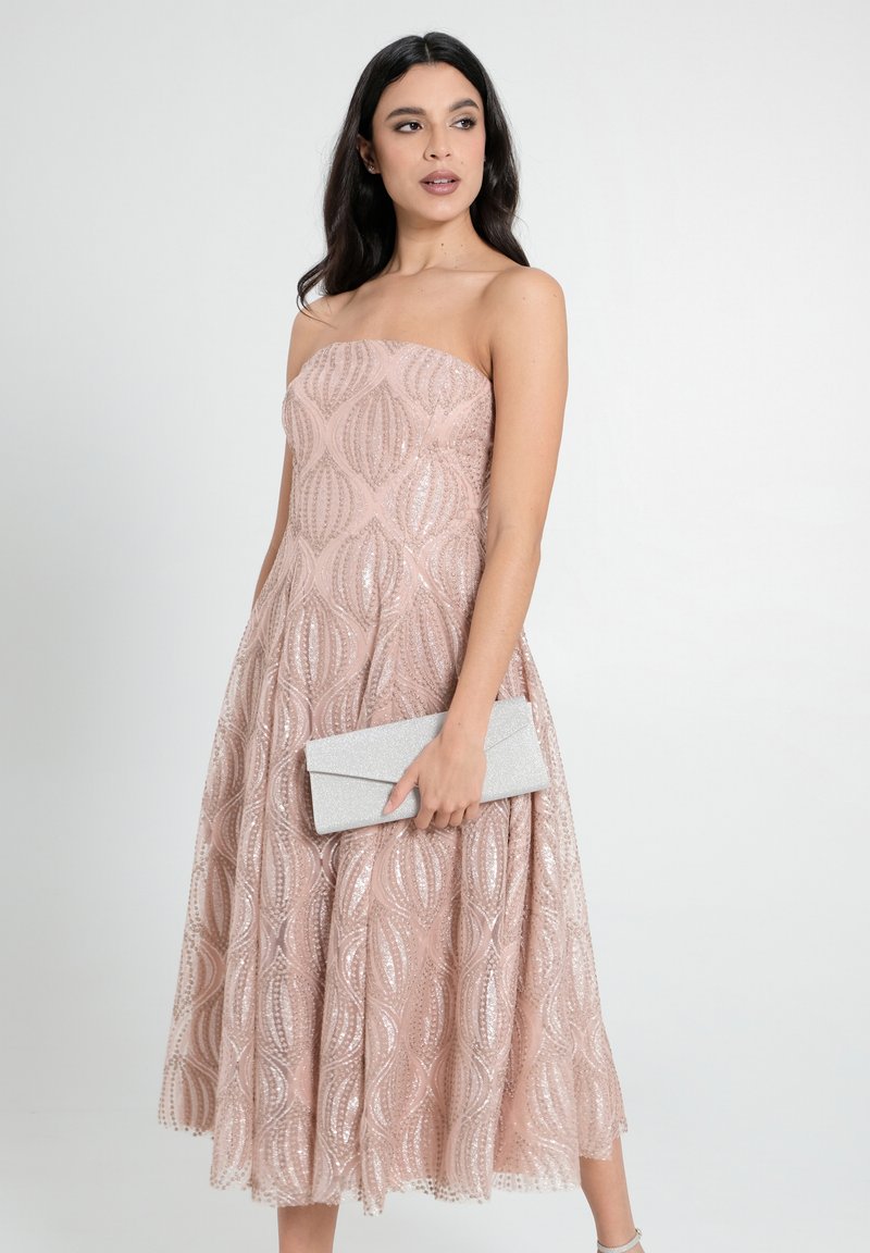 Trägerloses rosa Kleid mit komplexem Paillettenmuster, strukturiertem Stoff und weitem Rock, kombiniert mit einer silbernen Clutch.