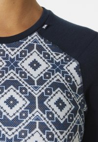 Dunkelblaues Langarmshirt mit einem gemusterten weißen und blauen Design auf der Vorderseite. Verfügt über einen Rundhalsausschnitt und kontrastierende strukturierte Ärmel.