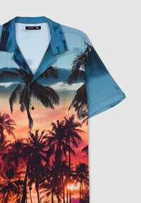 Camicia Button-up a maniche corte di colore blu con motivo palme al tramonto in arancione e nero. Realizzata in tessuto leggero, vestibilità rilassata.