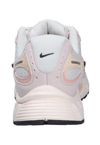 Rear view of white and pale pink Nike sneaker with mesh upper, cushioned sole, and black swoosh logo on heel tab.