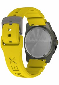 Reloj Timex con una correa de silicona amarilla y caja de acero inoxidable. La parte trasera es plateada con grabados, que muestran resistencia al agua de hasta 200m.
