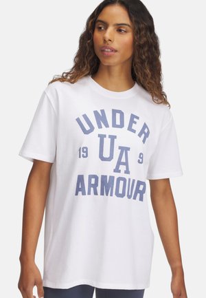 Camiseta blanca de algodón con cuello redondo, con llamativos gráficos azules: "UNDER ARMOUR 1996." Mangas cortas y corte relajado.