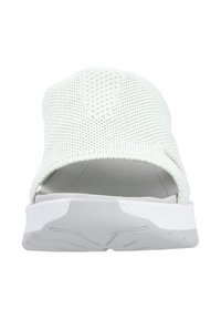 Bottine légères à enfiler de couleur vert clair, fabriquées en tissu tricoté respirant, avec une semelle en caoutchouc blanche présentant des motifs texturés et un design à dos ouvert.