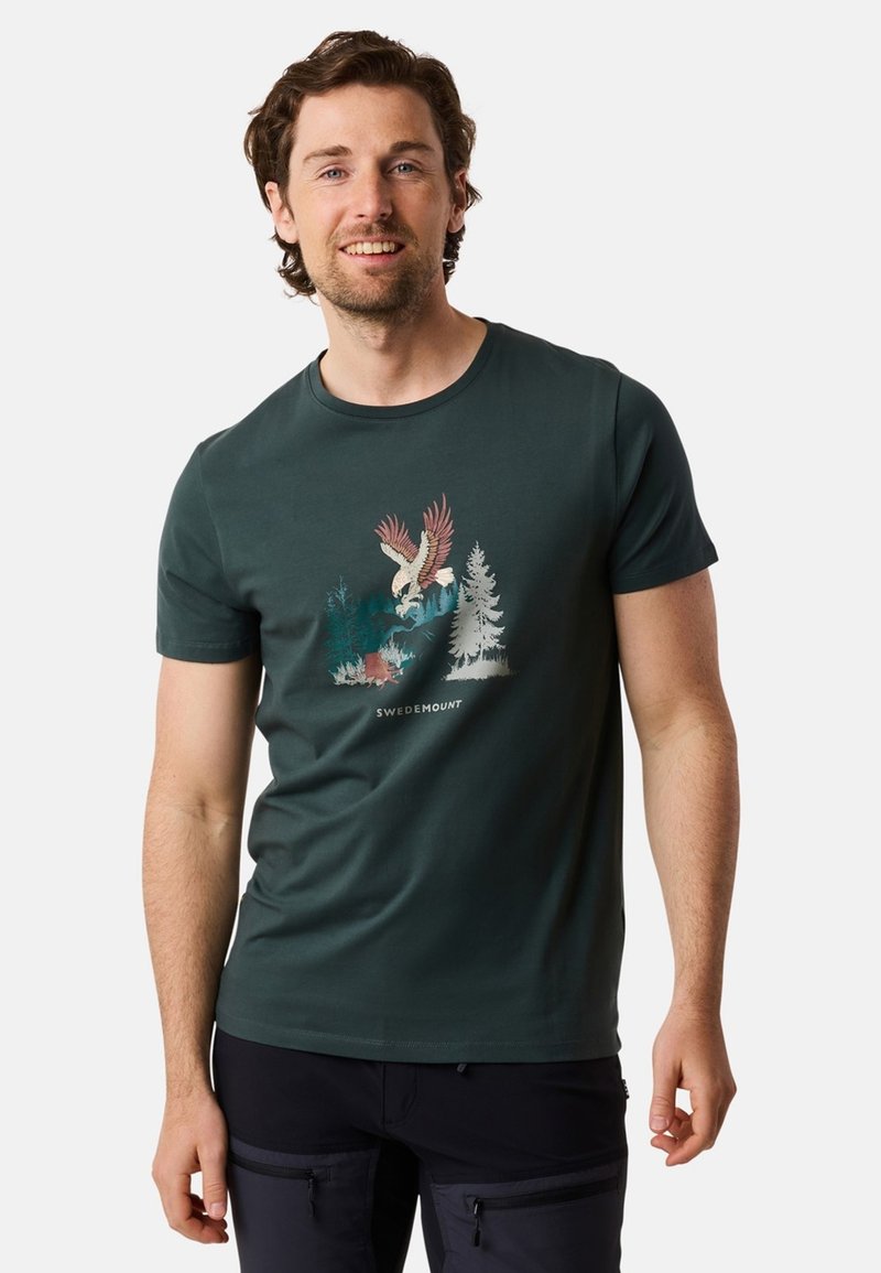 Mörkgrön bomull t-shirt med en framgrafik av en ödel och träd, med texten "SWEDEMOUNT" under designen. Korta ärmar, rundad hals.