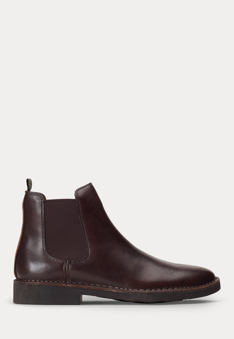 Stivale Chelsea in pelle marrone scuro con pannello laterale elastico e tacco basso, mostrato di profilo su sfondo bianco.