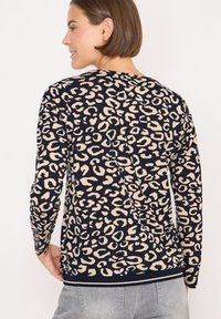 Maglietta a maniche lunghe realizzata in morbido tessuto con base blu navy e stampa leopardata beige, scollatura tonda e orli e polsini a coste.