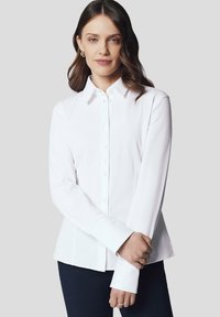 Biała koszula z długim rękawem i kołnierzykiem, charakteryzująca się gładką teksturą i dopasowanym krojem. Guziki ułożone wzdłuż przodu oraz wyprofilowane rękawy.