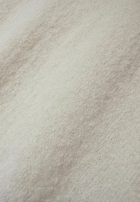 Tekstūrēta auduma gaisšbeige un krēma tonī, ar nemanāmām rakstu variācijām un maigu, austu izskatu.