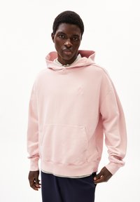 Felpa rosa chiaro con tasca frontale, cappuccio regolabile con cordino e dettaglio del logo ricamato. Tessuto morbido con polsini e orlo a coste.