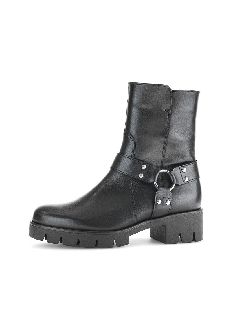 Bottines en cuir noir avec une semelle épaisse, dotées d'une sangle de boucle sur le côté et d'accents cloutés. Texture lisse et design épuré.