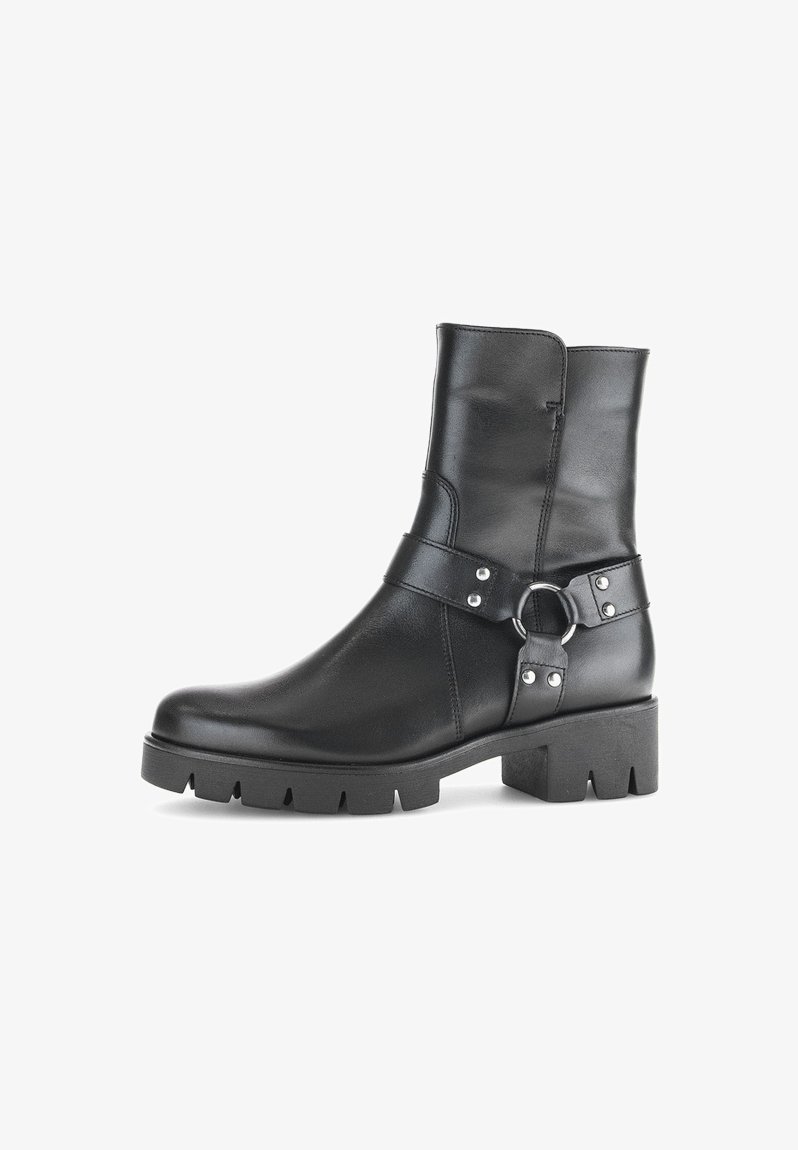 Bottines en cuir noir avec une semelle épaisse, dotées d'une sangle de boucle sur le côté et d'accents cloutés. Texture lisse et design épuré.