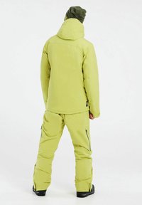 Helles Limettengrünes Outerwear-Set mit einer Kapuzenjacke und passenden Hosen. Strukturierter Stoff mit Reißverschlusstaschen und lockerer Passform.