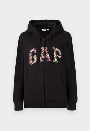Svart zip-up hettegenser med blomstrete "GAP" bokstaver; har foret hette, frontlommer, lange ermer og ribbestrikkede mansjetter.