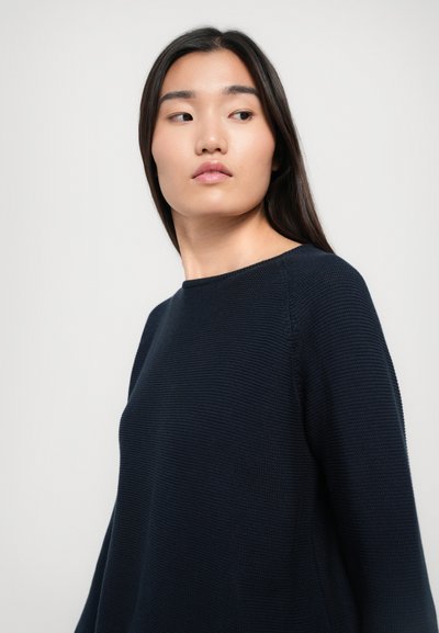 Marineblauer Strickpullover mit Rundhalsausschnitt, strukturiertem Stoff und lockerer Passform. Die Ärmel sind lang mit einem eingesetzten Design und einem gerippten Saum.