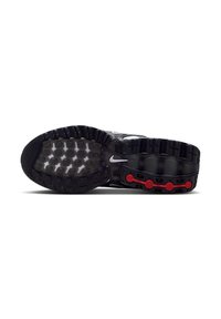 Black athletic shoe outsole featuring a textured rubber sole with red circular accents and a dotted grip pattern.  Includes a visible logo.