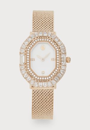 Gouden mesh-bandhorloge met een octagonale kast, witte wijzerplaat en kristalaccenten. Beschikt over een juwelen bezel en eenvoudige uur markers.