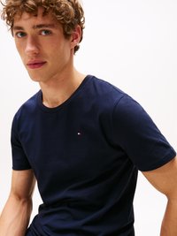 Navy blue cotton t-shirt featuring a round neckline and short sleeves, with a small red and white logo on the left chest area.
