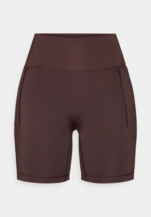 Smeđe sportske kratke hlače s visokim pojasom, izrađene od glatkog, rastezljivog materijala. Imaju bočne džepove i ojačane šavove.