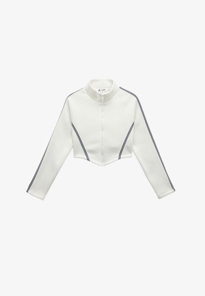 Hvid cropped zip-up jakke med lange ærmer, sorte dobbelte striber på ærmerne og foran, samt en høj krave.