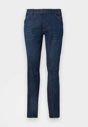 Donkerblauwe denim jeans met een slim fit. Voorzien van vijf zakken, een rits en subtiele stiksels langs de benen. Flat front ontwerp.