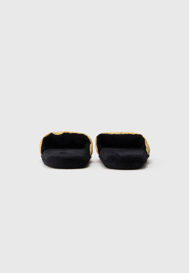 Schwarze Stoffslipper mit einem strukturierten goldenen Akzent am Eingangsbereich, ausgestattet mit einem weichen Innenfutter und einer runden Form für zusätzlichen Komfort.