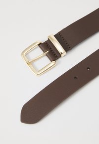 Ceinture en cuir marron avec une boucle rectangulaire en ton or et une texture lisse, dotée de trous espacés uniformément pour un ajustement.