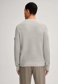 Hellgrauer Strickpullover mit einem strukturierten Muster, gerippten Bündchen und Saum sowie einem Rundhalsausschnitt. Der Stil ist lässig und tailliert.