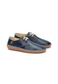 Zapatos de cuero azul marino con un acabado suave, con cordones beige, un borde cosido y una suela de goma marrón claro. Diseño sencillo y de perfil bajo.
