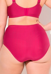 Ensemble de soutien-gorge fuchsia et culotte taille haute avec de fines rayures verticales. Comprend des bretelles réglables, une fermeture à crochets et des bords festonnés. Texture lisse.