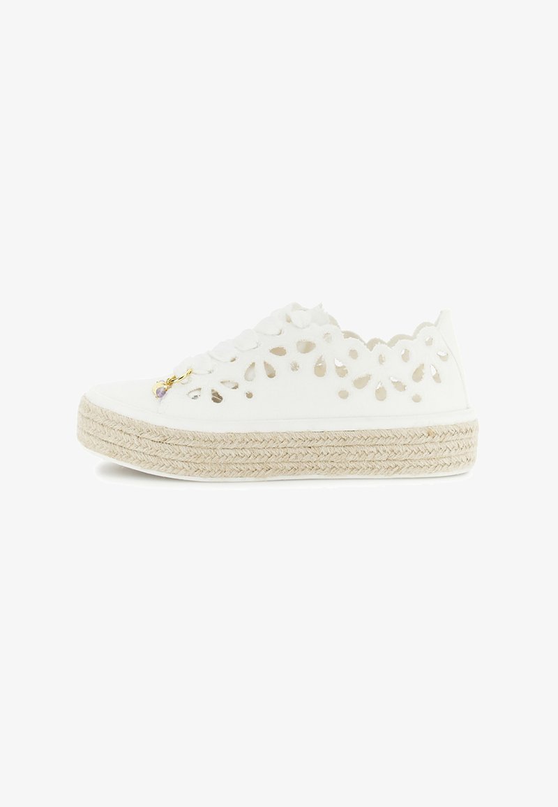 Zapatilla deportiva blanca tipo alpargata con cordones, con patrones florales troquelados y plataforma de yute trenzado, que cuenta con un pequeño charm dorado y morado.