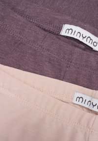 Twee paar meisjesachtige tanktops in mauve en zachtroze katoen. Voorzien van gestikte zomen en labels met het "minymo"-merk in een modern lettertype.