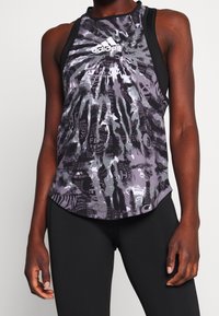 Czarny i szary sportowy top na ramiączkach z wzorem tie-dye i tekstowymi grafikami. Wykonany z lekkiego materiału, z tyłem typu racerback.