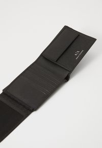 Portofel din piele neagră cu un finisaj texturat, având multiple sloturi pentru carduri și închidere prin clapetă. Include detalii cu logo pe interior.