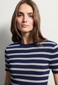 Top a righe in maglia caratterizzato da strisce orizzontali blu navy e grigio chiaro, maniche corte e scollatura rotonda. Tessuto liscio.