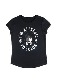 Sort T-shirt med et monokromt ansigt af en pige i midten, flankeret af to kranier, og tekst ovenfor og nedenfor, der siger "Jeg er allergisk over for farve."