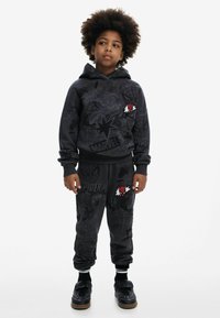 Zwarte hoodie en sweatpants met Spider-Man graphics en Marvel logo's, gemaakt van zachte stof met ribbels aan de mouwen en een ontspannen pasvorm.