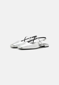Silver metallic slingback shoes with a pointed toe, flat heel, and adjustable ankle strap. Smooth texture with minimalistic design.