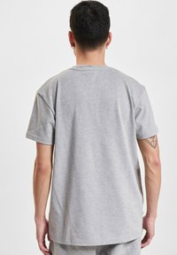 Szara bawełniana koszulka z krótkim rękawem, klasyczny krój i gładka faktura. Posiada okrągły dekolt oraz delikatne detale na krawędzi.