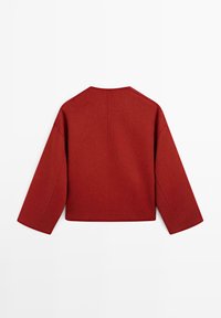 Giacca rossa in misto lana con taglio dritto, spalle scese e maniche lunghe. Presenta un design posteriore senza cuciture e uno stile minimalista.