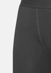 Zwarte stretchlegging met een gladde textuur, voorzien van een brede tailleband en versterkte naden voor duurzaamheid.