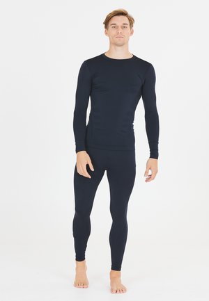 Navyblauwe lange mouw top en legging gemaakt van rekbare stof, met een getailleerd ontwerp en textuuraccenten langs de armen en benen.