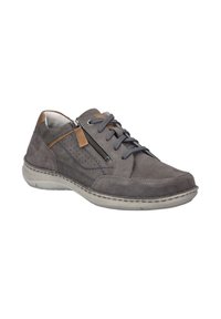 Sneaker in suede grigio con un design testurizzato, dettagli in marrone a contrasto, una cerniera laterale e lacci grigi. Suola leggera e flessibile.