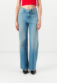 Hochtaillierte, weite blaue Jeans aus hellblauem Denim. Merkmale sind zwei vordere Taschen, ein Knopfverschluss und ein ausgebleichtes Finish.